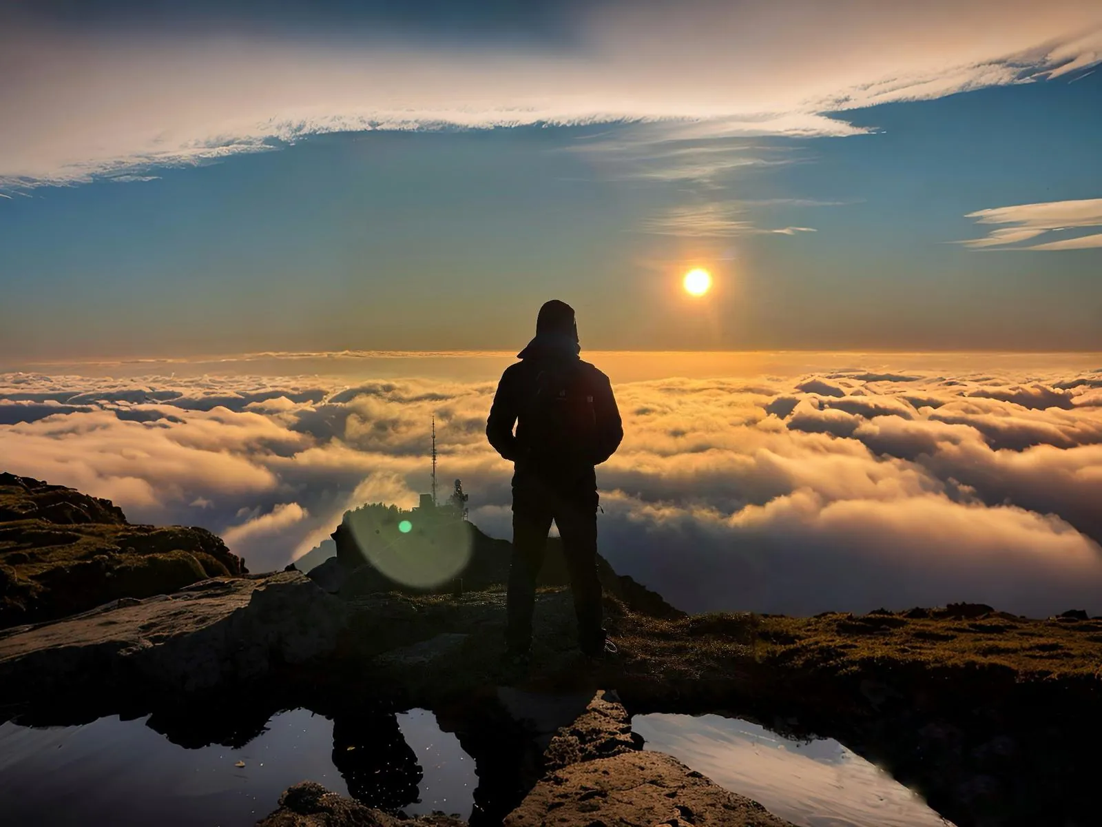 Foto di un escursionista su una cresta al di sopra delle nuvole